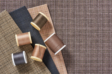 Spools of threads on checkered cotton fabric for quilting and applique