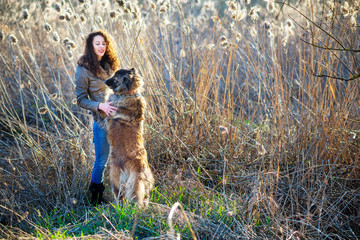 Girl playing with Caucasian shepherd dog, autumn
