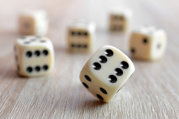 Rolling dice on a wooden desk.