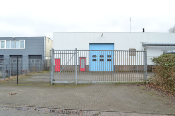 bedrijfsgebouw achter een hekwerk op industrieterrein