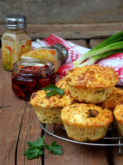salty snack cakes muffins with cheese, tomatoes and parsley on wooden background - selective focus