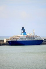 Fototapeta na wymiar Großes Kreuzfahrtschiff im Hafen vor Anker liegend - blauer Himmel im Hintergrund