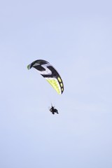 Paraglider mit Rotor vor leicht bewölktem Himmel