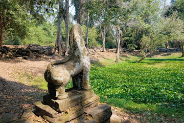 Fototapeta na wymiar Lion in the foreground guarding Preah Khan Temple in Angkor Complex, Siem Reap, Cambodia. Ancient Khmer architecture and famous Cambodian landmark, World Heritage.