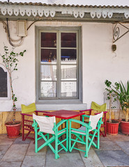 Greece, colorful chairs and table