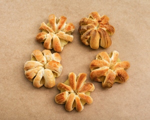 Five round buns in shape flower arranged in a circle on the surface of the natural. Rings of pineapple cooked in puff pastry. Beautiful dessert.