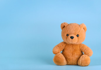 Toy teddy bear on blue background with copy space