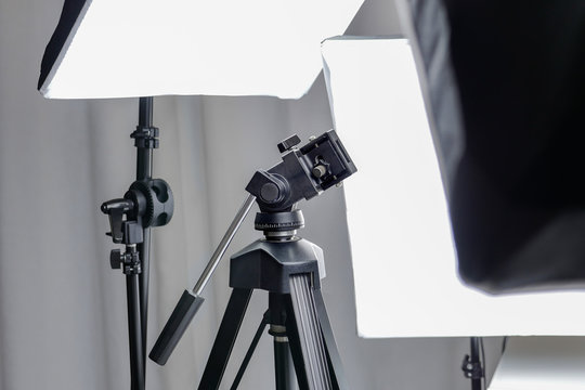 Camera tripod in a photo studio with lightning equipment