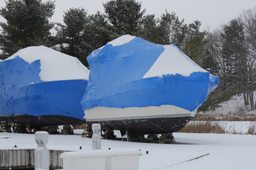 Blue shrink wrap on boats covered in during the winter season as protection against elements.