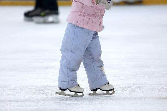 child girl skates on ice rink