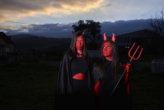 Dos mujeres j&oacute;venes disfrazadas de demonio en Halloween