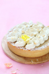 Obraz na płótnie Canvas Contemporary Easter Coconut Tart on wooden board, on light pink background.