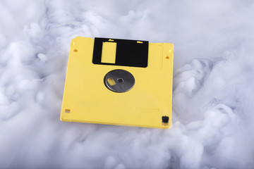 Yellow old and retro floppy disc. Information cloud conceptual image