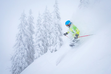 Freeride skiier riding in deep powder snow