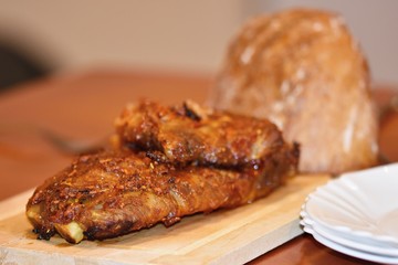 Roasted pork ribs. On wooden background and bread.