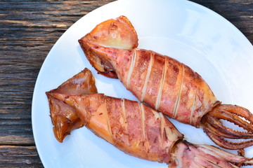 Grilled squid on white plate on wood table,sea food of Thailand