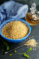 Quinoa in a blue bowl. Vinegar in background