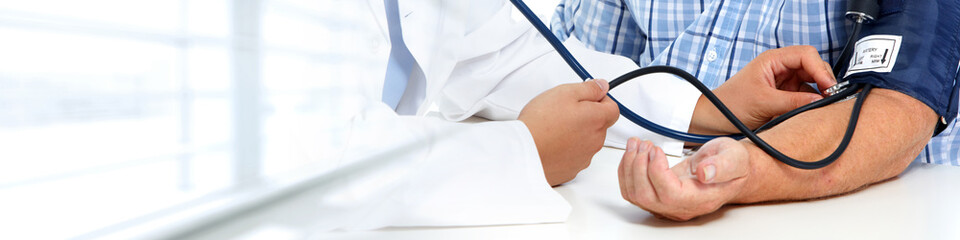 Doctor measuring patient blood pressure.