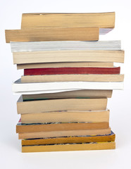 Tall stack of used paperback books.
