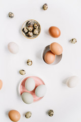 White and brown Easter eggs and quail eggs on white background. Flat lay, top view. Traditional spring concept.