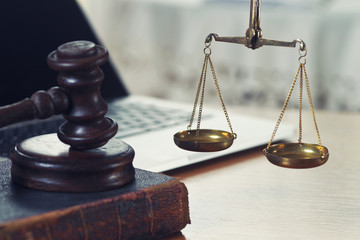 Law composition with scale and gavel on old brown leather book