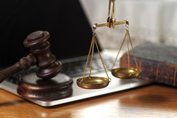 Law composition with scale and gavel on old brown leather book
