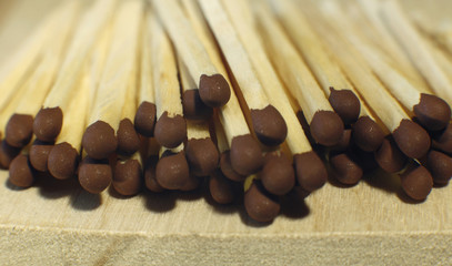 Matchsticks with brown tips on a birch board macro close up