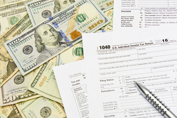 Fototapeta na wymiar 1040 Individual Tax Return form on top of a table full of paper money.