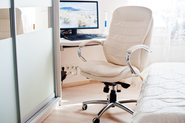 White leather luxury office chair background monitor of computer at light room.