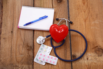 Heart with a stethoscope, isolated on wooden background