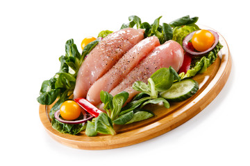 Raw chicken breasts on cutting board 