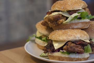Chickenburgers with cheese, bacon and salad on a plate