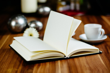 Notizbuch, Croissant und Kaffeetasse auf Holztisch