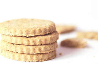 Pile of cookies or biscuits and crumbs on white background