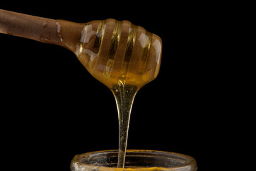 honey wooden spoon isolated on a black background