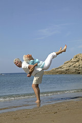 Glueckliches Senioren Paar im Urlaub, hat Spass am Strand