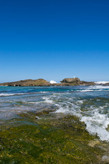 Fototapeta na wymiar Seascape: beach, rocks and blue sky