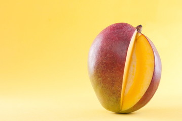 cut mango isolated on a yellow background