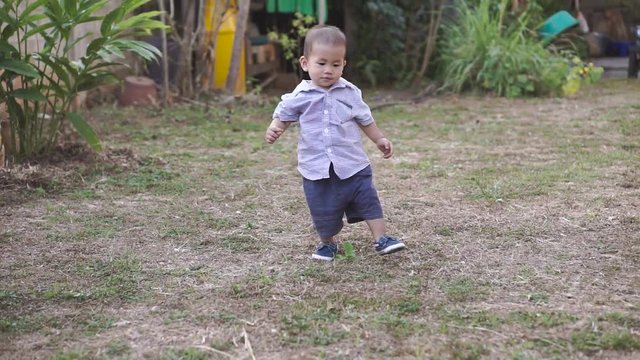 Asian boy about 1 year and a month learning to walk and fall on his own