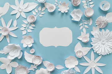 Vintage frame with white paper flowers on blue background. Cut from paper.