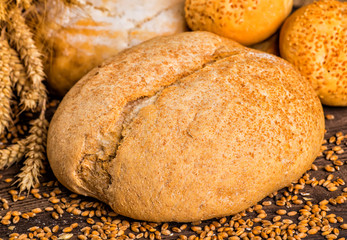 Assortment of baked bread on wooden table background
