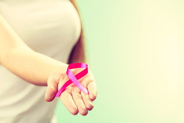 Woman with breast cancer awareness ribbon on hand