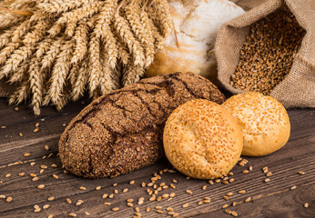 Assortment of baked bread on wooden table background