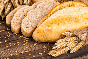 Assortment of baked bread on wooden table background