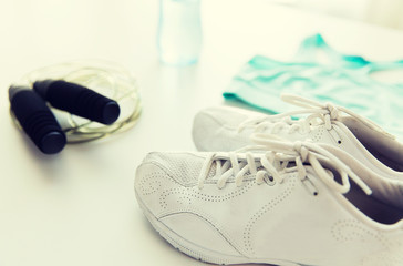 close up of sportswear, skipping rope and bottle