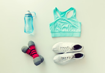 close up of sportswear, dumbbells and bottle