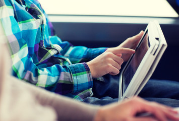 close up of boy with tablet pc in travel bus