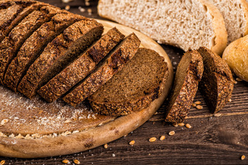 Assortment of baked bread on wooden table background