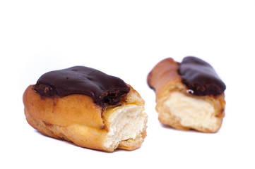 Cake eclair custard is broken in half isolated on white