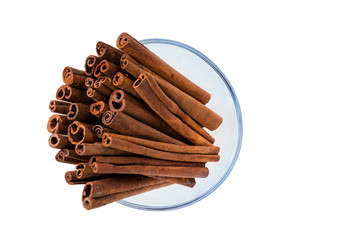 Cinnamon sticks  in a glass bowl  on white background,macro shot